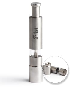 Triturador de tempero feito de metal prateado, com design moderno e tecnológico. O dispositivo possui um recipiente de plástico para armazenar os temperos, com um plug elétrico para ligar a energia. O equipamento é usado para moer temperos e ervas, garantindo praticidade na cozinha.