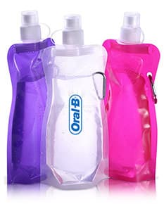 Squeeze plástico dobrável de 480ml em destaque, acompanhado de diversos acessórios como sapatos, mochila, luvas de beisebol, mouse de computador, binóculos e máscara. Objeto moderno e prático, ideal para o dia a dia.
