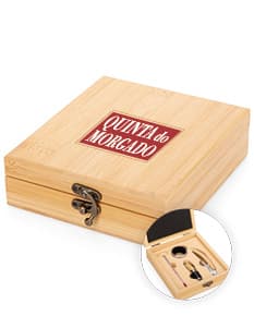 Caixa de papelão marrom aberta com 4 peças de kit de vinho dentro, incluindo um abridor de garrafas, um cortador de lacre, um anel antigotejamento e um termômetro. A caixa de papelão está vazia e preparada para transporte e armazenamento.